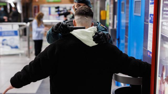 Un agente de la Guardia Civil cachea a un joven en un control para prevenir la violencia entre bandas juveniles, en la estación de metro de Arganda del Rey, a 11 de febrero de 2022.