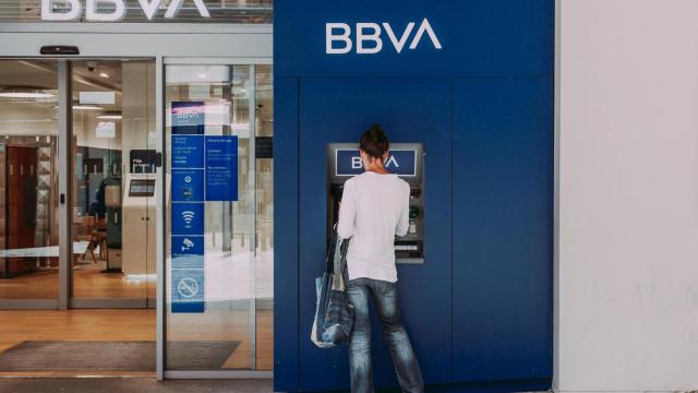 Una mujer retira dinero del cajero del banco BBVA.