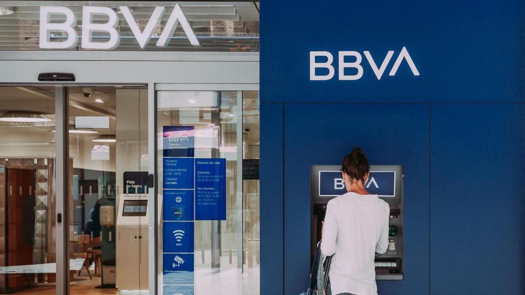 Una mujer retira dinero del cajero del banco BBVA.