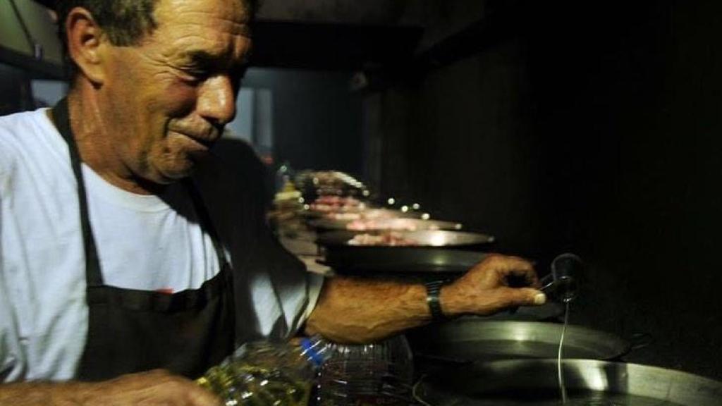 El padre de los cuatro hermanos cocinando una paella