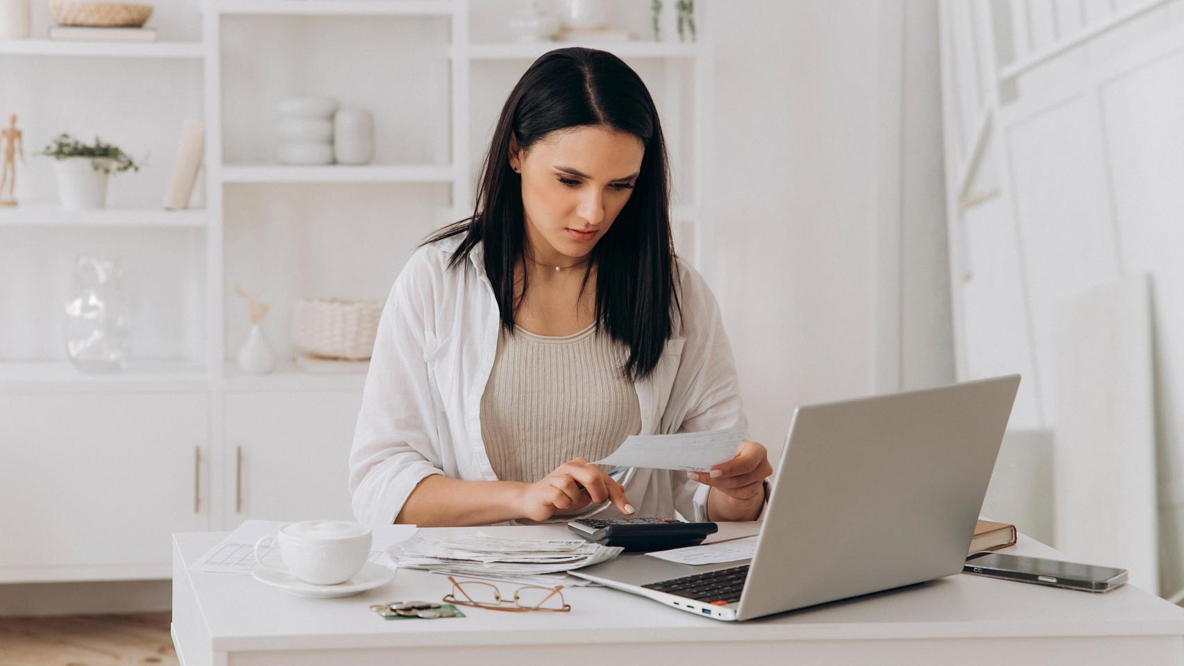 Una mujer repasando sus facturas en una imagen de ShutterStock.