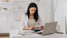 Una mujer repasando sus facturas en una imagen de ShutterStock.