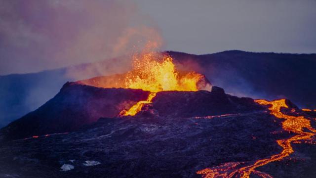 Río de lava junto al volcán en erupción.