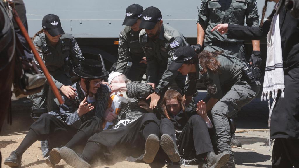 Varios policías cargan contra ultraortodoxos judíos en las afueras de Tel Aviv en el primer día de reclutamiento militar tras décadas de exención.