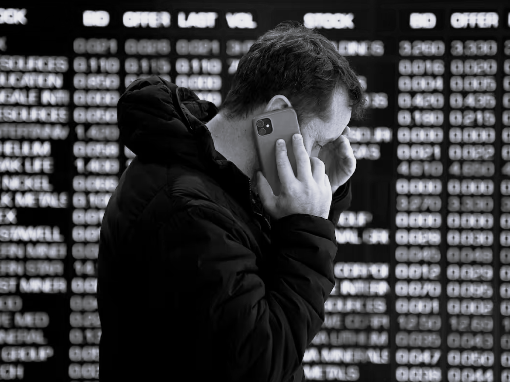 Una persona habla por teléfono frente a los paneles indicadores en la Bolsa de Valores de Australia en Sídney, este lunes.