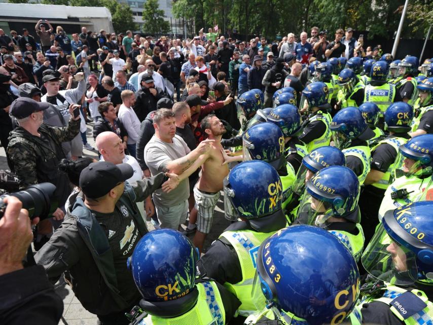 Un manifestante se encara con la policía británica.