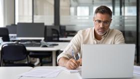 Un hombre realiza una tarea con su ordenador, en una imagen de ShutterStock.