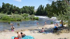 Varias personas disfrutan en la playa fluvial salmantina