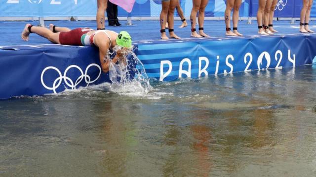 Triatleta mojándose la cara en el río Sena durante los Juegos Olímpicos de París.