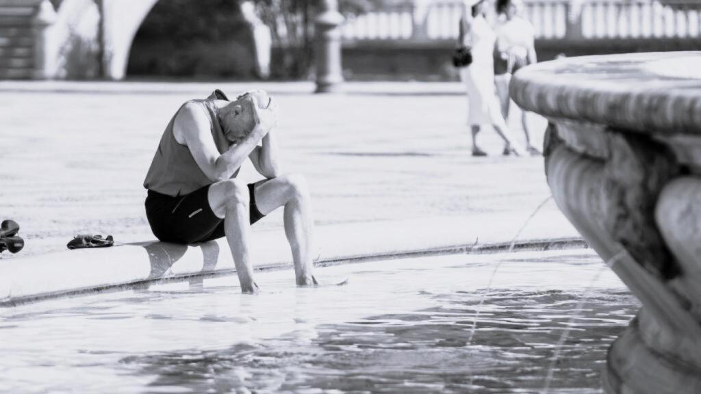 Un hombre trata de refrescarse en Sevilla.