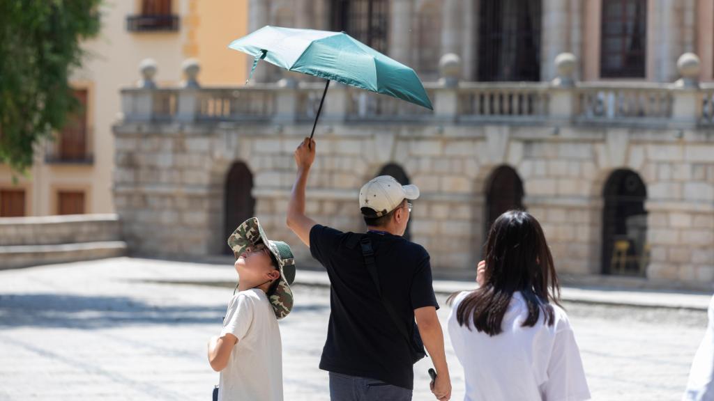 Unos turistas pasean con paraguas por las calles de Toledo.