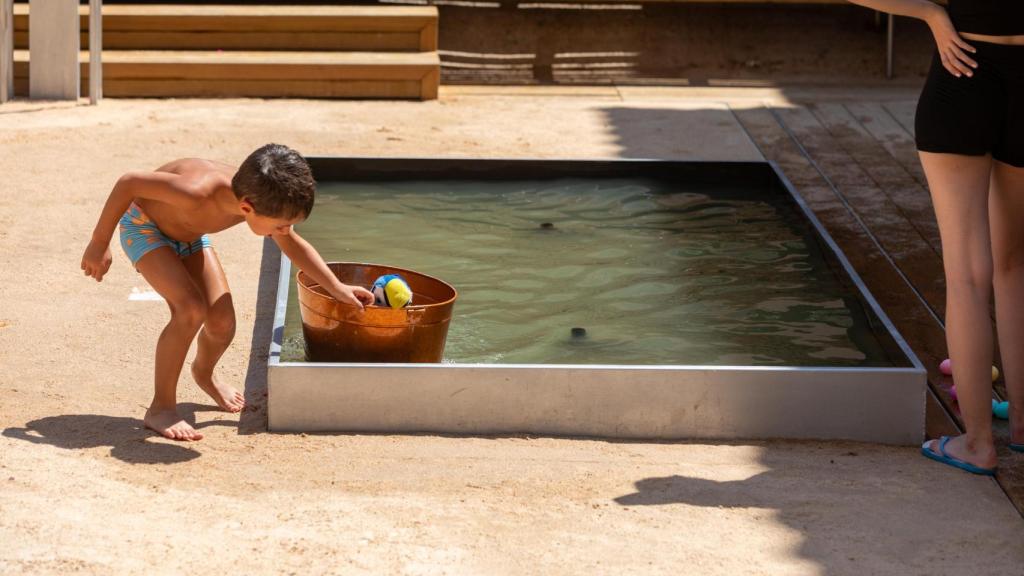 Un niño juega en una fuente.