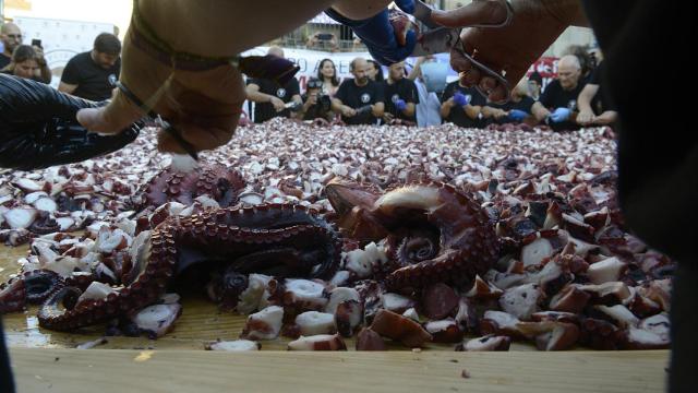 Personas trocean pulpo en O Carballiño, a 9 de agosto de 2022, en O Carballiño.