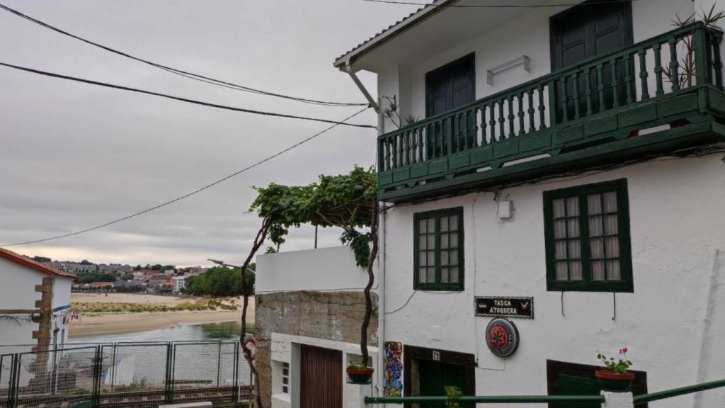 La taberna marinera A'Toquera, con la ría de A Coruña y Santa Cristina al fondo.