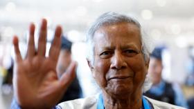 Nobel laureate Muhammad Yunus, who was recommended by Bangladeshi student leaders as the head of the interim government in Bangladesh, waves at Paris Charles de Gaulle airport in Roissy-en-France