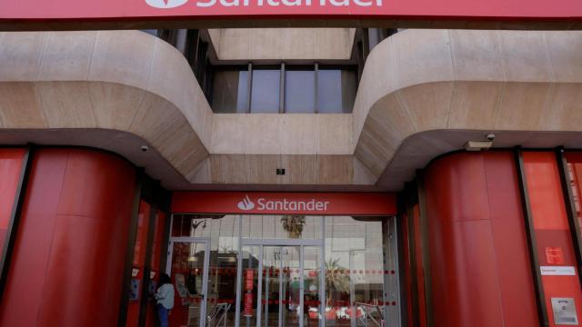 Una mujer utiliza un cajero en una sucursal de Santander.