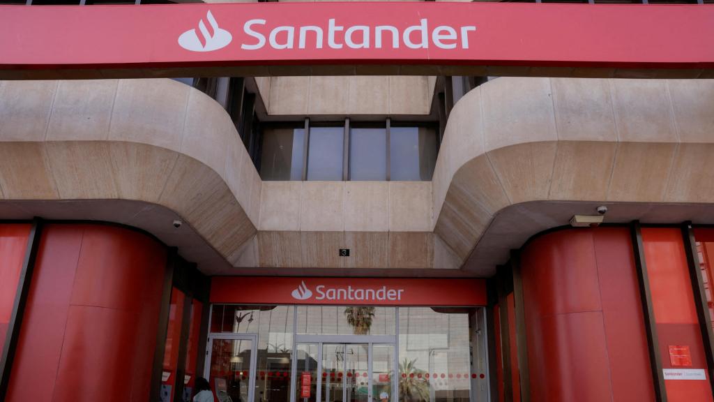 Una mujer utiliza un cajero en una sucursal de Santander.