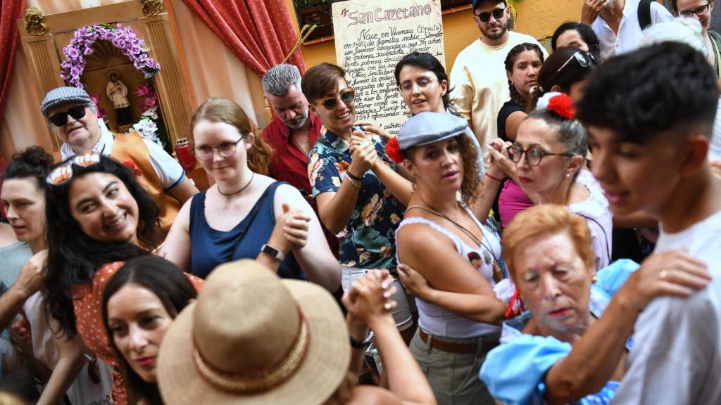 Varias personas bailan durante las fiestas de San Cayetano 2024, en la calle del Oso, este martes.