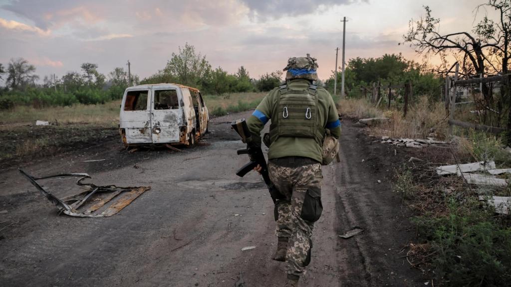 Un militar de la 24a Brigada Mecanizada Separada Rey Danylo de las Fuerzas Armadas de Ucrania corre por la calle en una línea del frente, en medio del ataque de Rusia a Ucrania , cerca de la ciudad de Chasiv Yar en la región de Donetsk.