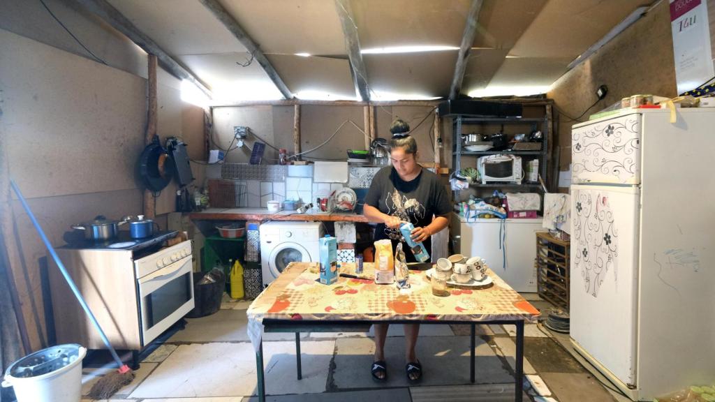 Un familiar de Paco cocina en el interior de la chabola de Paco Soarez en El Vacie.