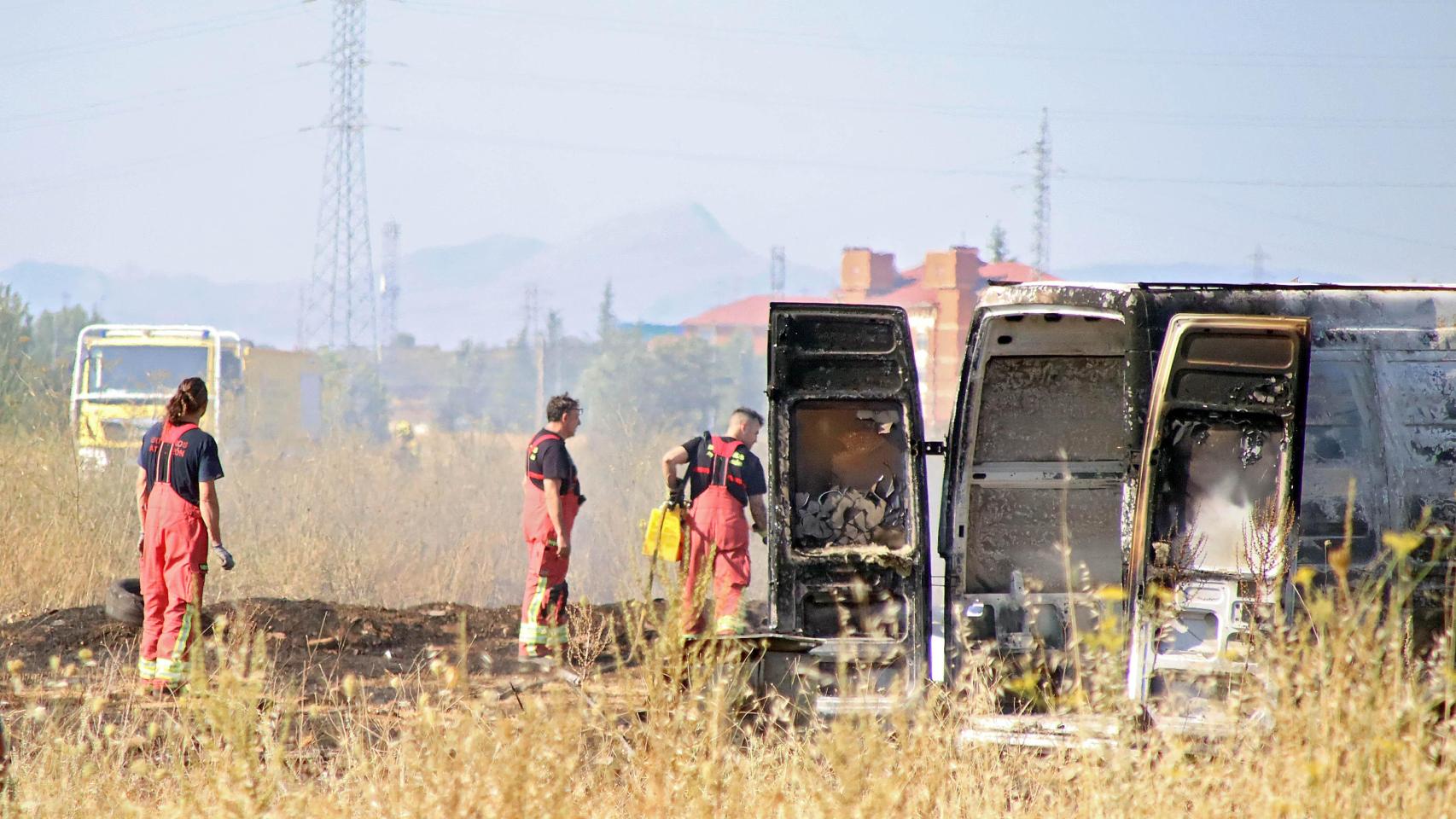 Imagen de los bomberos junto al vehículo calcinado por el incendio