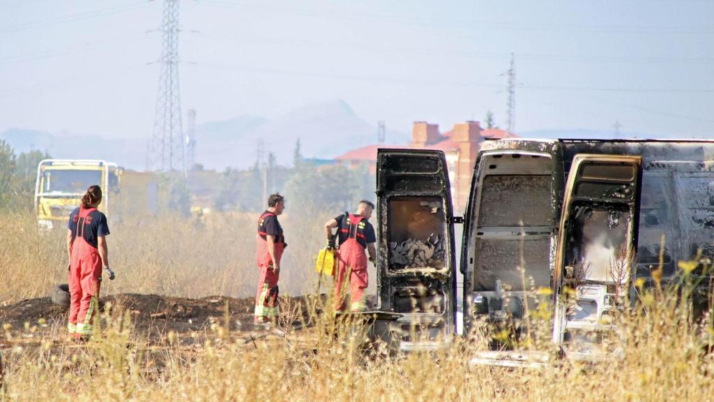 Imagen de los bomberos junto al vehículo calcinado por el incendio