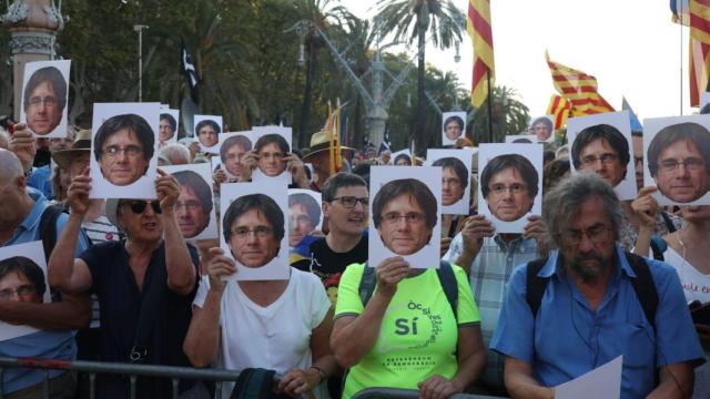 Los manifestantes colocándose la cara de Puigdemont sobre la suya.