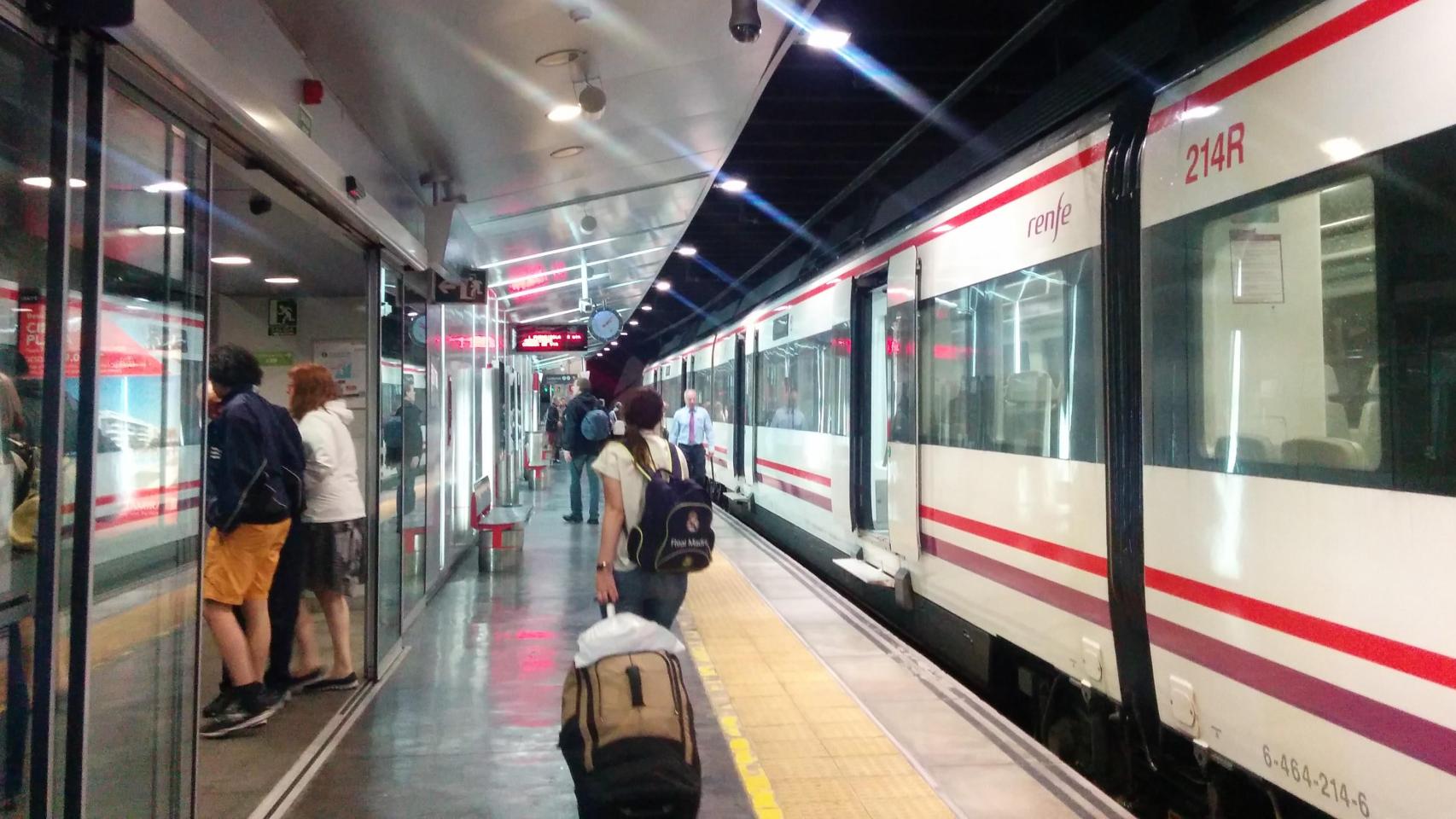 Una pasajera pasa junto a un tren de Cercanías de Málaga.