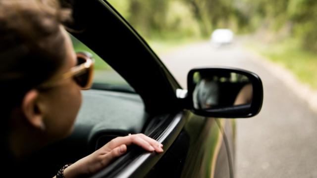 Una chica mirando por la ventana durante un viaje en la carretera.