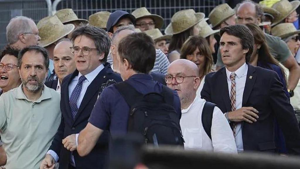 Carles Puigdemont rodeado de varios voluntarios, que colaboraron con la maniobra de distracción colocándose sombreros de paja.