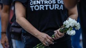 Una mujer sostiene flores durante la gran vigilia nacional por los presos políticos de la dictadura socialista venezolana.