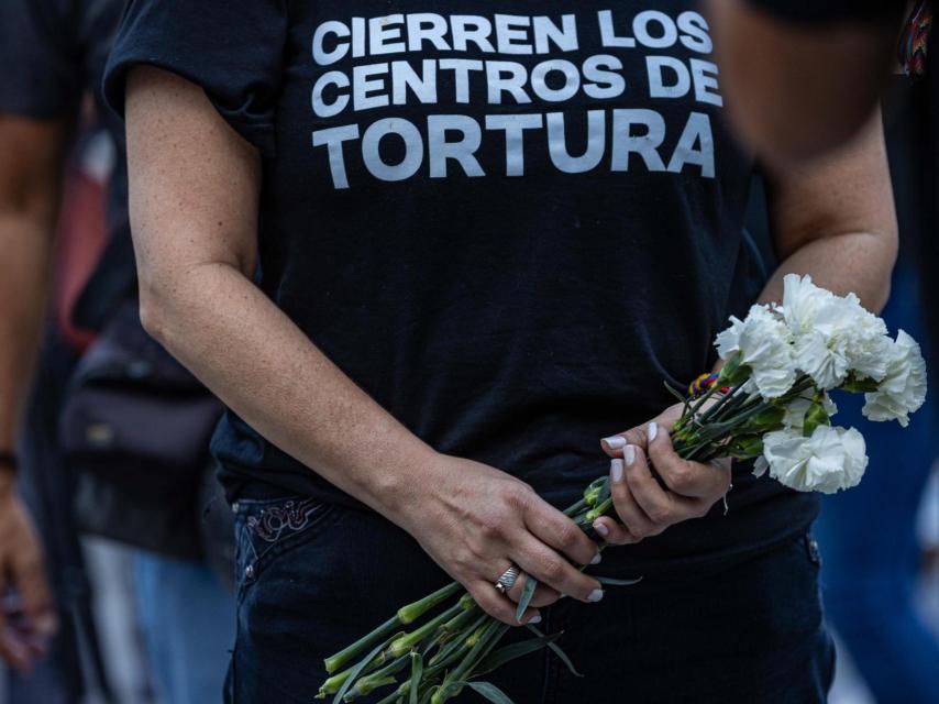 Una mujer sostiene flores durante la gran vigilia nacional por los presos políticos de la dictadura socialista venezolana.