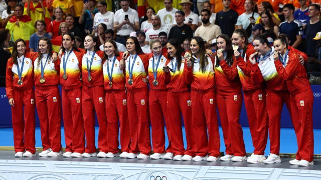 Las jugadoras de la selección de waterpolo femenino posan con la medalla de oro.