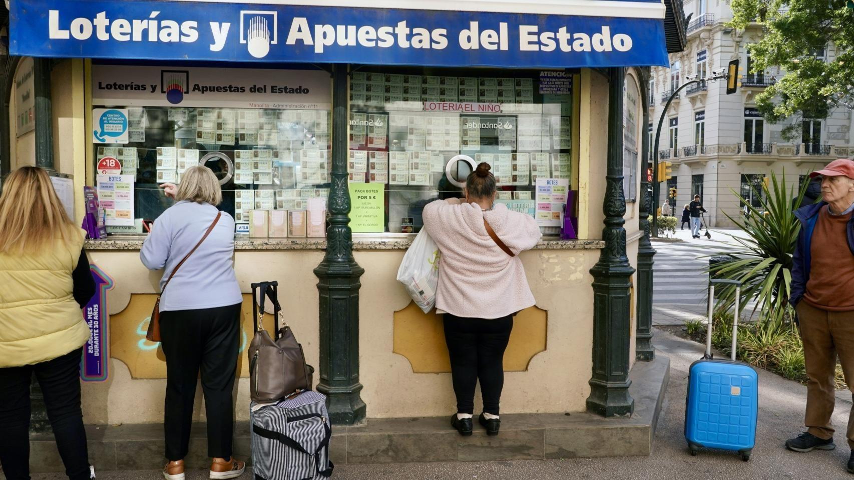 Varias personas en una administración de Lotería de Málaga.