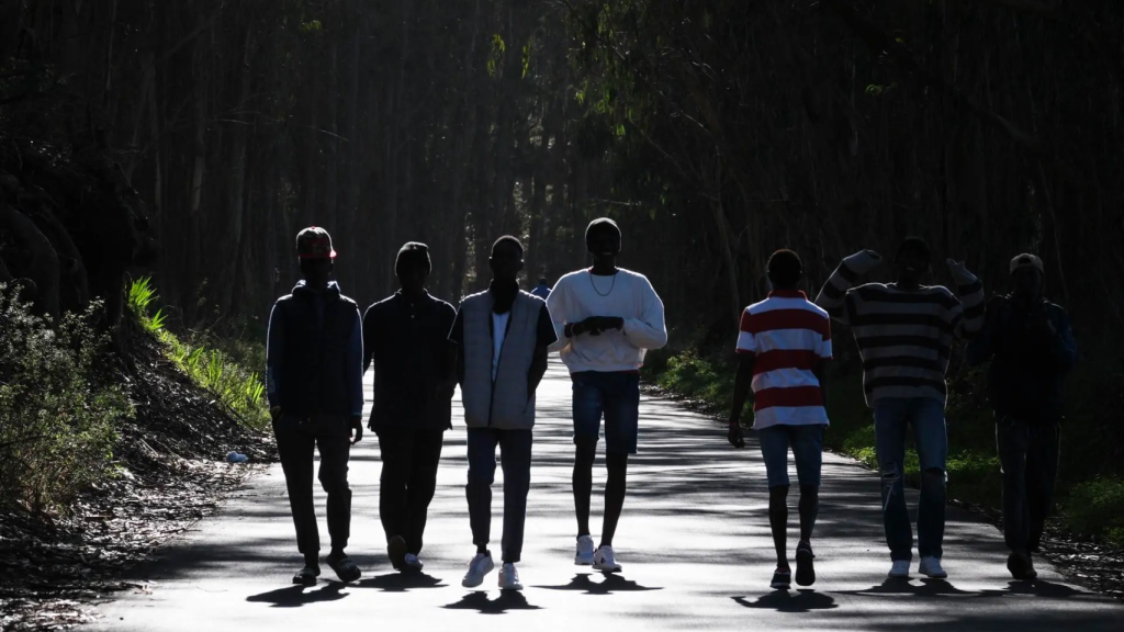 Un grupo de jóvenes africanos llegados a Canarias en cayuco camina por las cercanías del centro de acogida para extranjeros de Las Raíces, en La Laguna (Tenerife).