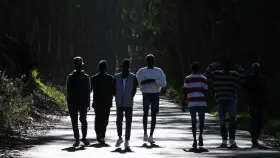 Un grupo de jóvenes africanos llegados a Canarias en cayuco camina por las cercanías del centro de acogida para extranjeros de Las Raíces, en La Laguna (Tenerife).