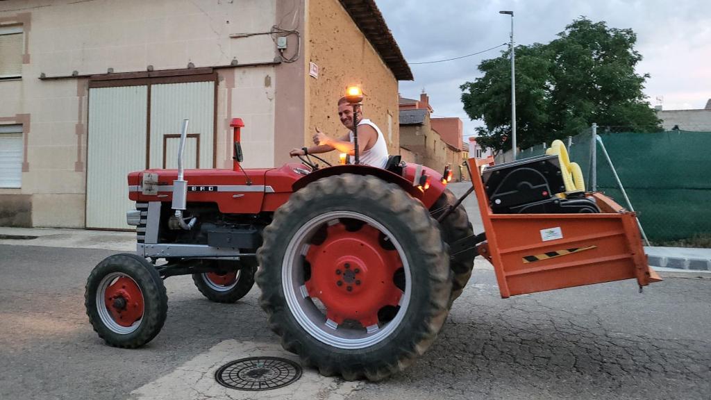 Juanma pasea por el pueblo con su tractor recién arreglado.