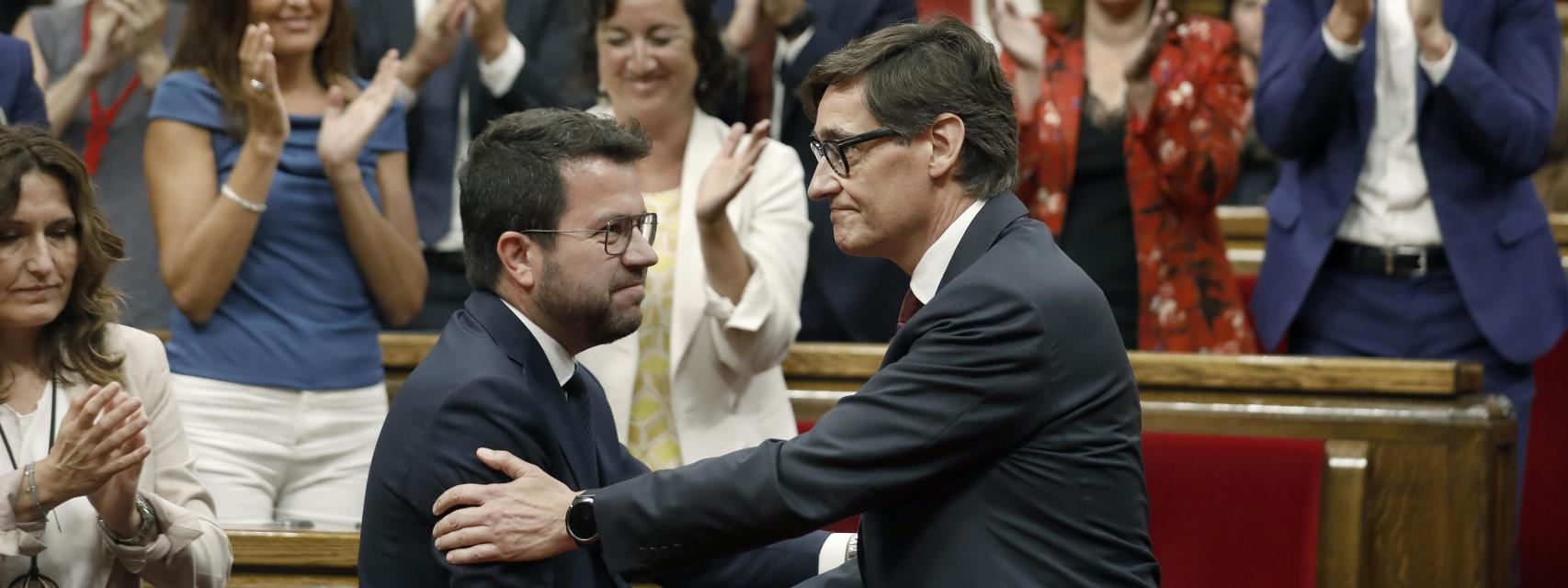 El candidato y líder del PSC Salvador Illa (d) saluda a Pere Aragonés tras ser investido president durante el pleno del debate de investidura en el Parlament de Cataluña