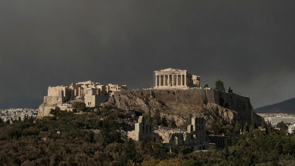 El templo del Partenón en la cima de la colina de la Acrópolis mientras se ve el humo de un incendio forestal, en Atenas.