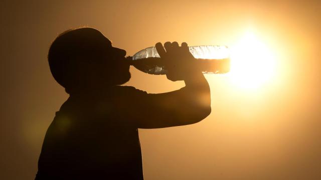 Una persona bebiendo agua por la ola de calor