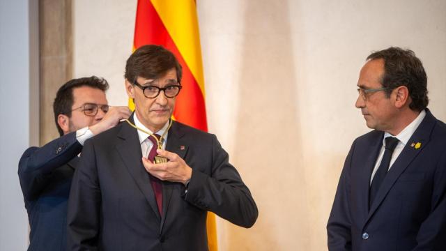 Pere Aragonés coloca a Salvador Illa la medalla de presidente de la Generalitat, el sábado ante la mirada del presidente del Parlament, Josep Rull.