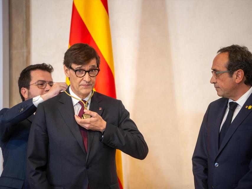 Pere Aragonés coloca a Salvador Illa la medalla de presidente de la Generalitat, el sábado ante la mirada del presidente del Parlament, Josep Rull.