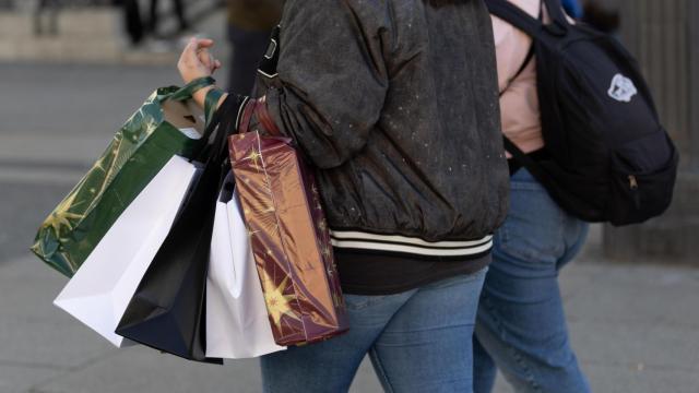 Una persona lleva varias bolsas de compra.