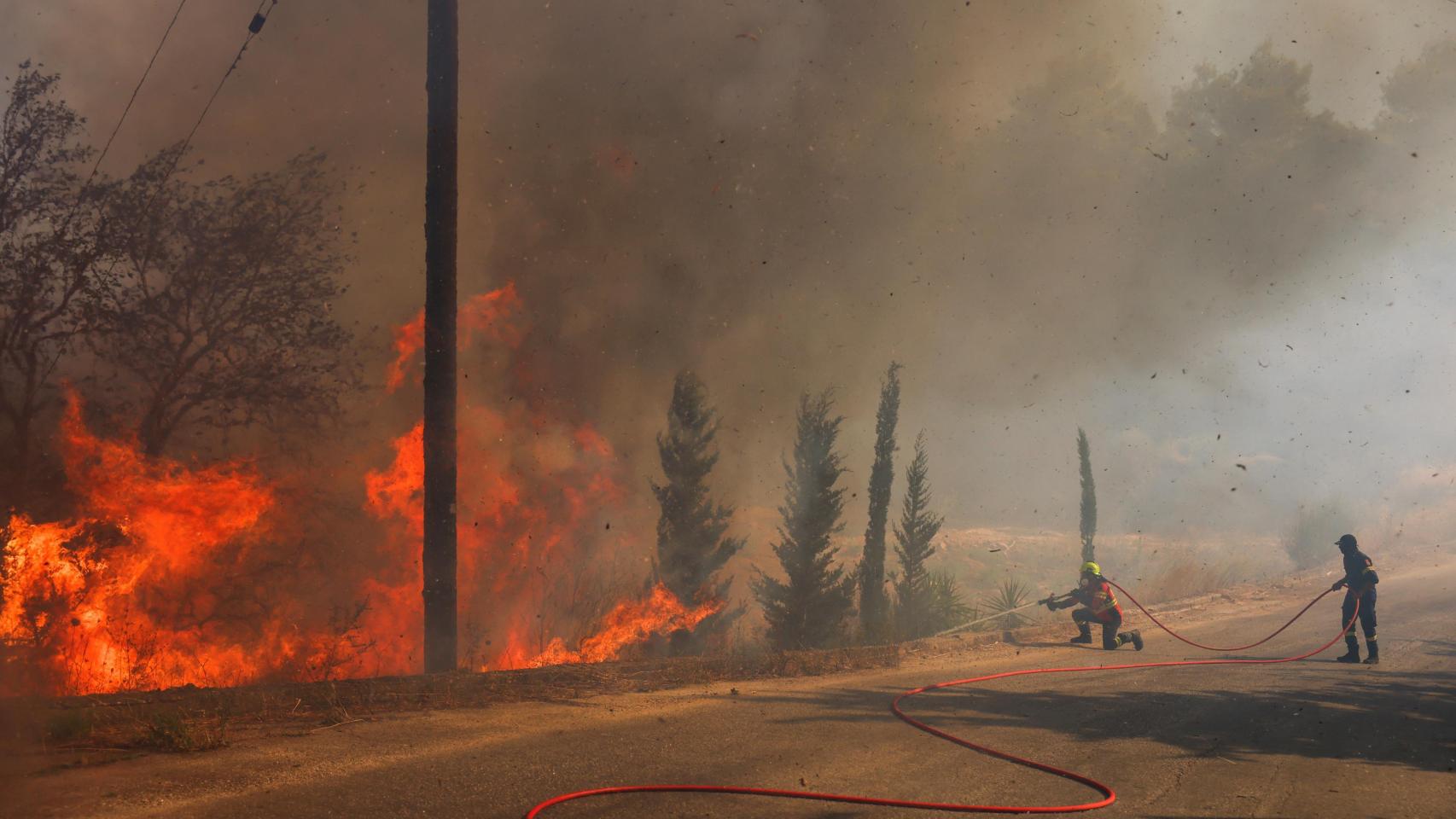 Los bomberos intentan extinguir un incendio forestal en Grammatiko, cerca de Atenas.