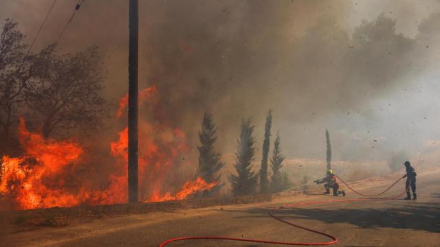 Los bomberos intentan extinguir un incendio forestal en Grammatiko, cerca de Atenas.