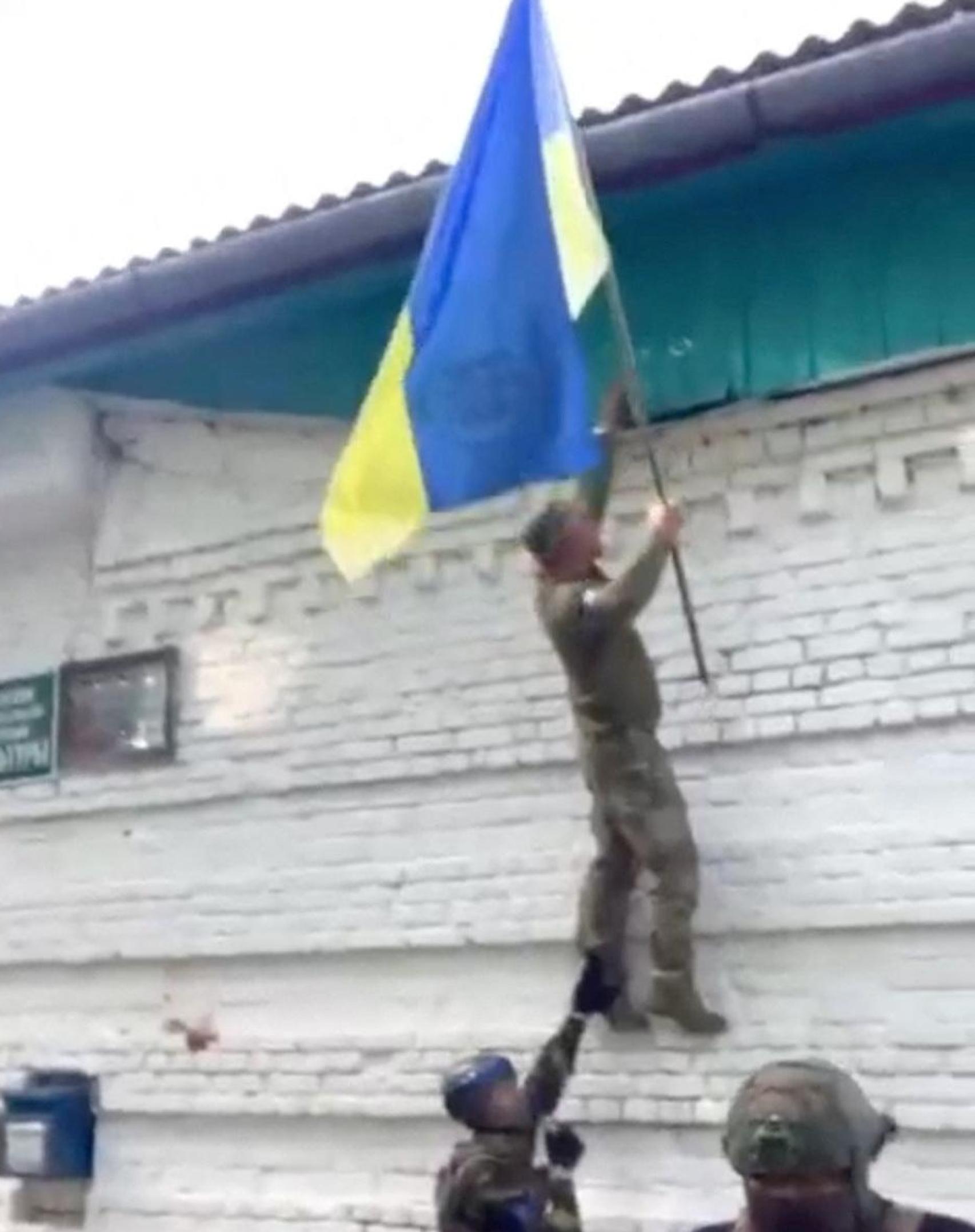 Un soldado ucraniano iza una bandera ucraniana en Guevo, en la región rusa de Kursk.