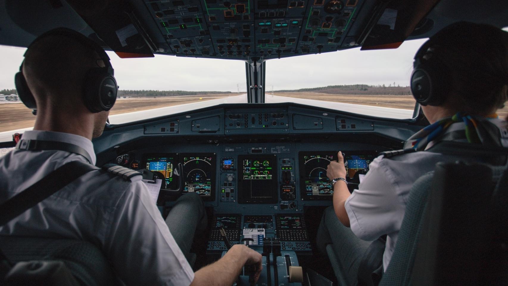 Pilotos en la cabina de un avión comercial en el proceso de despegue