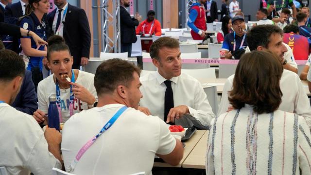 Emmanuel Macron comiendo con atletas franceses en la Villa Olímpica