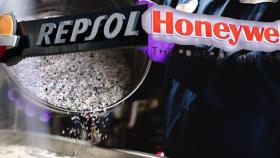 Los logos Repsol y Honeywell con un fondo de plásticos reciclados.