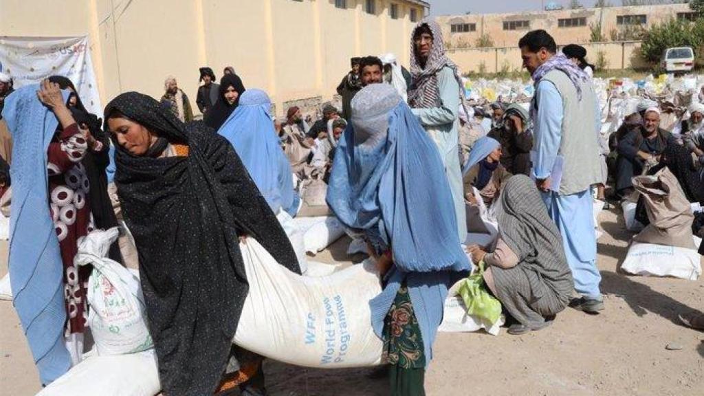 Mujeres afganas ayudando a repartir alimentos para combatir la pobreza.